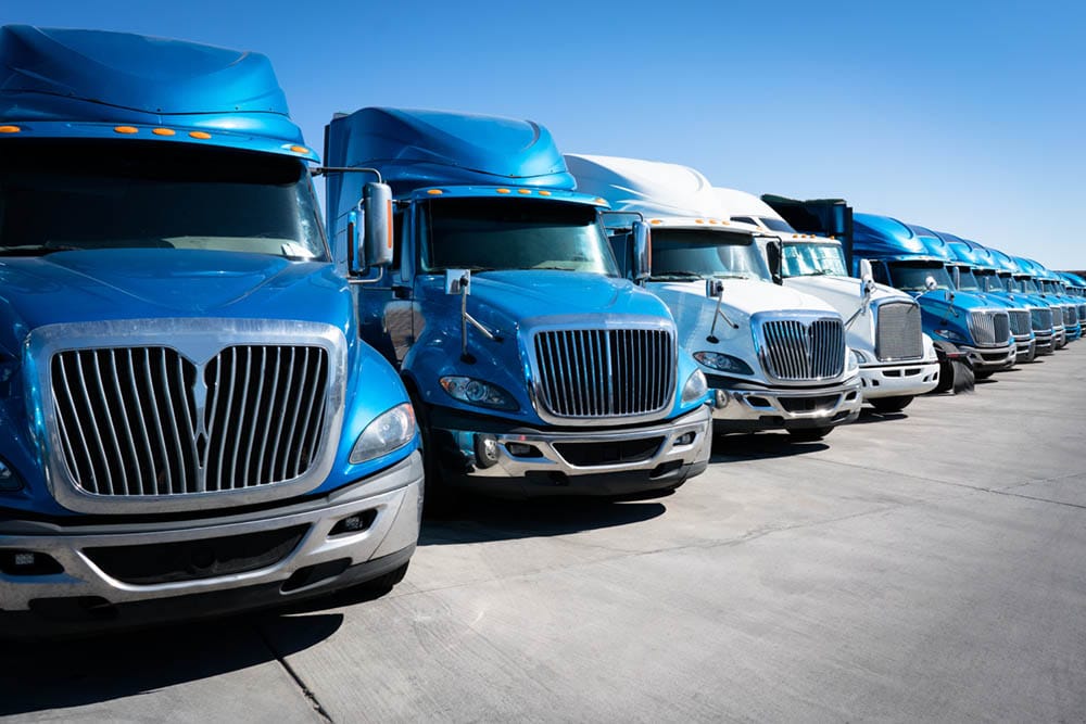 Fleet of blue 18 wheeler semi trucks