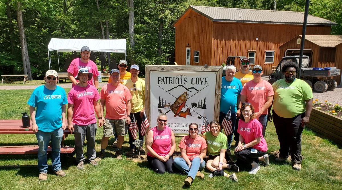 UGI employees pose around Patriots Cove sign.